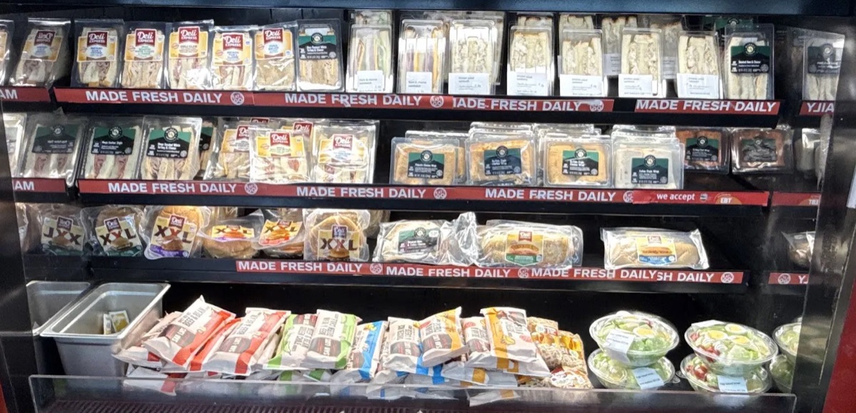 Grab-and-go cooler of sandwiches, wraps, burritos and salads labeled Made Fresh Daily