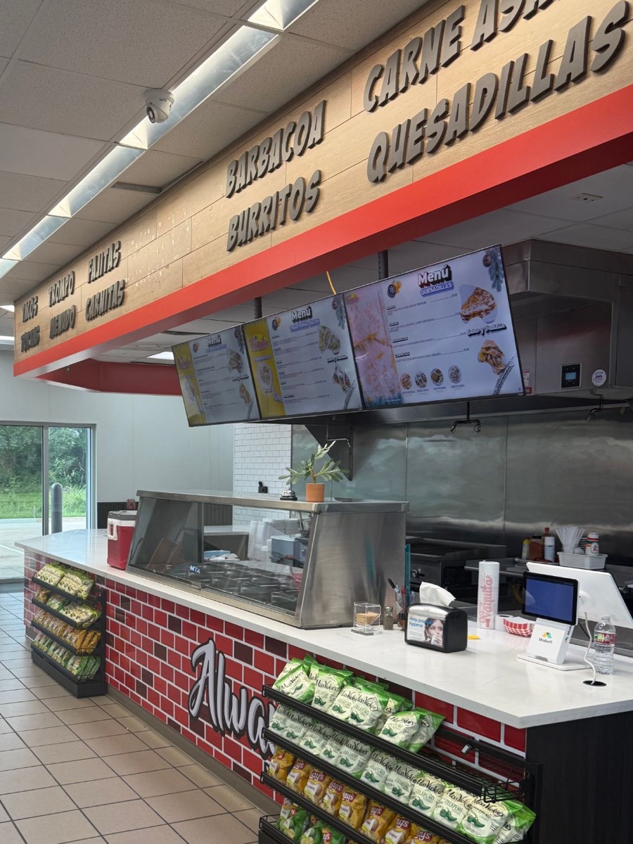 Mexican food counter with menu boards for tacos, burritos, quesadillas and carne asada